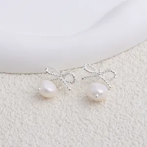 Dettaglio orecchini a fiocco color argento con perle naturali d'acqua dolce bianche