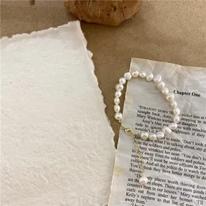 Close-up detail of a vintage baroque natural pearl necklace on retro paper
