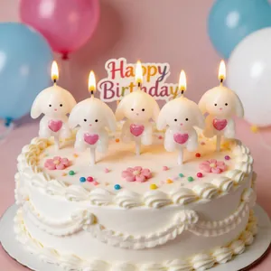 Set of 5 cute bunny birthday candles with pink hearts displayed on a white cream cake