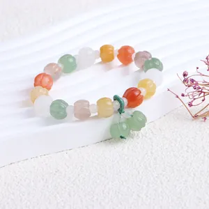 Detailaufnahme eines bunten Armbands mit natürlichen Jadeperlen in Kürbisform.