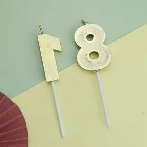 Primer plano de velas de cumpleaños doradas número 18 para decoración de pasteles