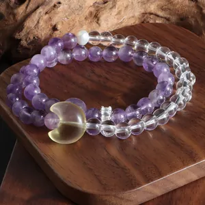 Vue rapprochée d'un bracelet améthyste et quartz clair avec un pendentif de lune