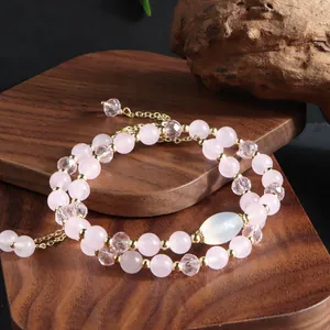 Detailed macro shot of a rose quartz double-strand bracelet on a natural wood display