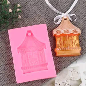 Detailed view of pink silicone carousel mold alongside finished plaster ornament with ribbon