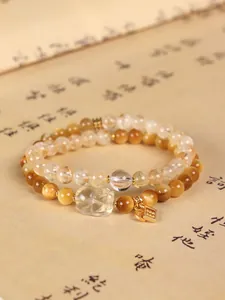 Detailed shot of yellow tiger eye and citrine double-layer bracelet with carved Pixiu charm