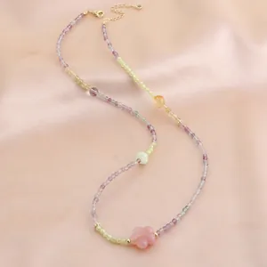 Détail du collier en perles de fluorite et calcédoine colorées avec un pendentif fleur rose