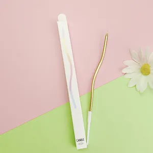 Detail of a single gold curved birthday cake candle with its white slim cardboard packaging box