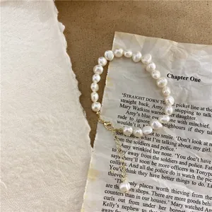 Detailed view of white baroque natural pearl necklace with adjustable gold lobster clasp