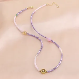 Élégant collier de perles en cristal naturel aux tons roses et violets avec pendentif doré.