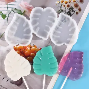 Detailed macro view of monstera leaf silicone mold and finished colorful leaf lollipops