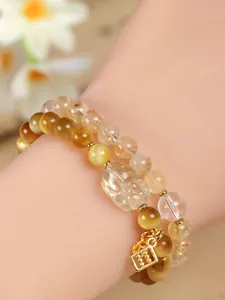 Close-up of double-strand tiger eye and citrine beaded bracelet with PiXiu charm