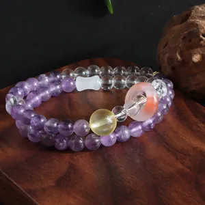 Close-up of double-layer amethyst and citrine beaded bracelet on a wooden surface