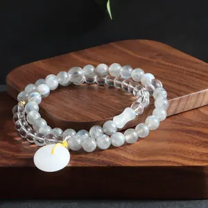 Detailed view of grey moonstone and clear crystal double-strand bracelet with white charm.
