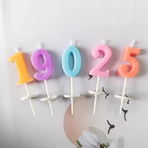 Detailed view of colorful pastel number candles with white holders for cake decoration