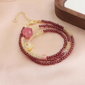 Vue détaillée d'un bracelet multicouche en perles de grenat avec fermoir doré élégant