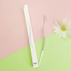 Close-up detail showing a silver curved birthday candle and minimalist white packaging