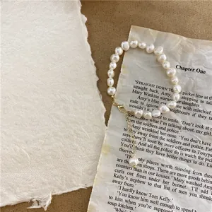 Macro view of vintage baroque natural pearl necklace on retro paper background