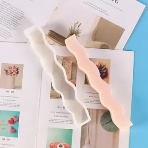 Gros plan d'un moule en silicone ondulé et d'une bougie parfumée rose en forme de bande