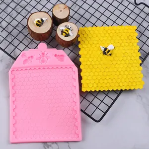 Detailed view of pink silicone honeycomb and bee pattern mold with yellow sample