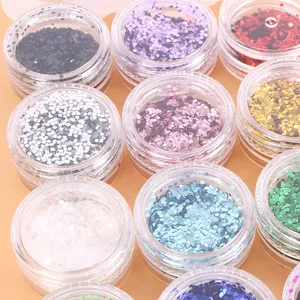 Vue détaillée de paillettes hexagonales colorées stockées dans des pots ronds clairs