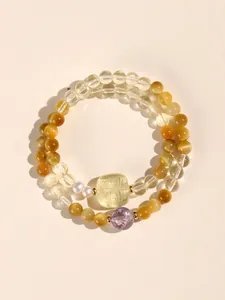 Detail of double strand citrine and tiger eye bead bracelet with amethyst and pearl accents.