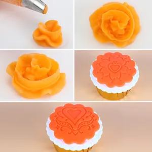 Detail of cake piping tip creating orange frosting rose and heart embossed cupcake topper.