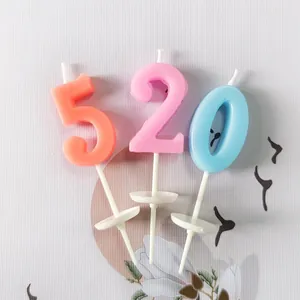 Close-up of small colorful number candles 520 with white plastic holders for cake