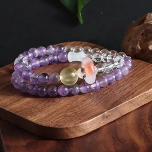 Close-up of double-layer amethyst and citrine beaded bracelet on wooden stand