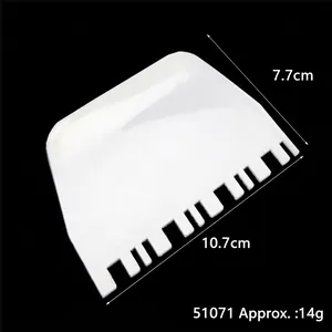 White plastic baking scraper with comb edge dimensions 10.7x7.7cm