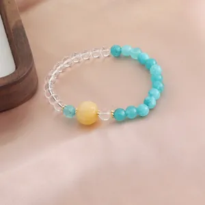 Detailansicht eines Naturkristall-Armbands mit klaren und türkisfarbenen Perlen