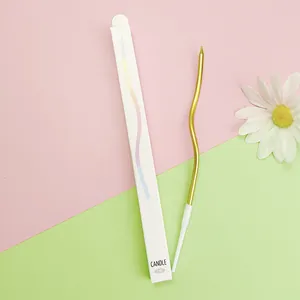Detailed view of a gold curved birthday candle and its minimalist white packaging box.