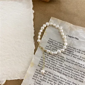 Macro view of natural white baroque pearl necklace on a vintage storybook paper