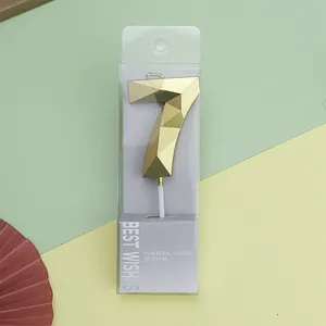 Vista detallada de la vela de cumpleaños número 7 dorada y geométrica en caja