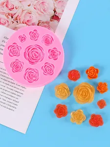 Detail of pink rose silicone mold for fondant alongside various colorful resin flowers