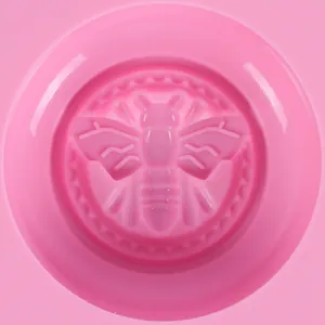 Detailopname van een roze bijenmotief in een ronde siliconen vorm voor zeep en om te bakken