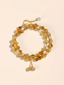 Top view of a double-layer yellow tiger's eye beaded bracelet with gold charms