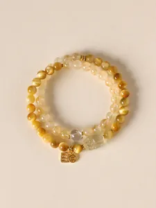 Close-up detail of yellow tiger eye and citrine double layer beaded bracelet with Pixiu charm