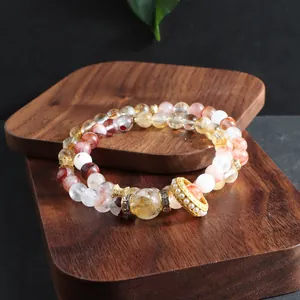 Detailed view of a multi-strand natural crystal bracelet displayed on a wooden stand
