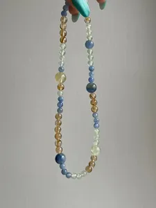 Macro view of a handcrafted necklace featuring natural kyanite, citrine and fluorite beads