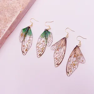Detailed view of handmade cicada wing earrings with gold leaf flakes and gradients