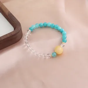 Nahaufnahme eines natürlichen Kristallperlenarmbands mit türkisfarbenen und klaren Edelsteinen