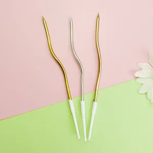 Close-up view of elegant curved gold and silver birthday candles for party cake decoration.
