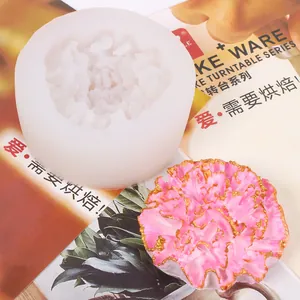 Detailed view of a carnation-shaped silicone mold alongside a finished pink flower.