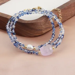 Gros plan du collier de perles en cristal bleu à trois rangs avec Pixiu en calcédoine