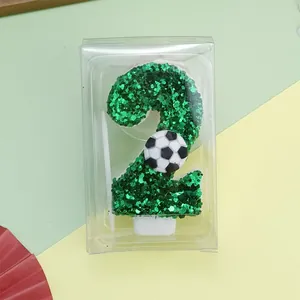 Detail der grünen Glitzer Nummer 2 Fußball Geburtstagskerze in ihrer klaren Geschenkbox