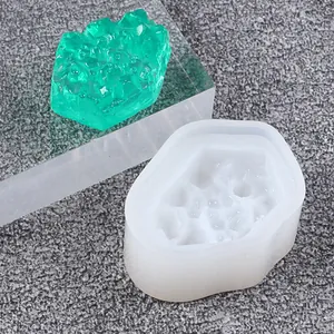 Nahaufnahme der Silikonform und des fertigen grünen Harz-Kristallclusters aus Kunstharz.