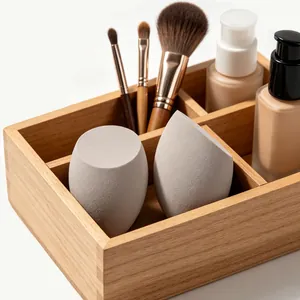 Close-up of grey slanted and teardrop beauty blenders in a wooden organizer box.