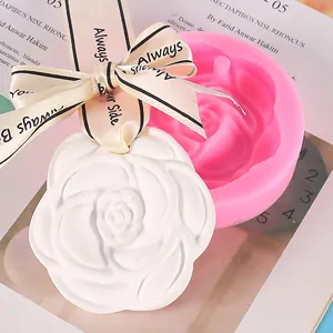 Gedetailleerde close-up van de roze siliconen mal en witte camelia gipsen hanger voor geur
