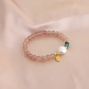 Detailed view of natural strawberry quartz bead bracelet featuring a pearl and golden pendant