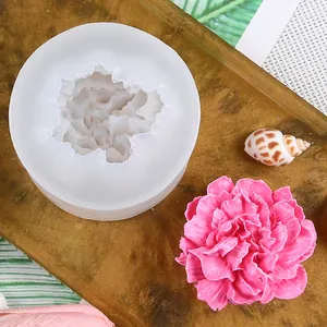 Detailed view of a carnation-shaped silicone mold next to a pink plaster flower sample.